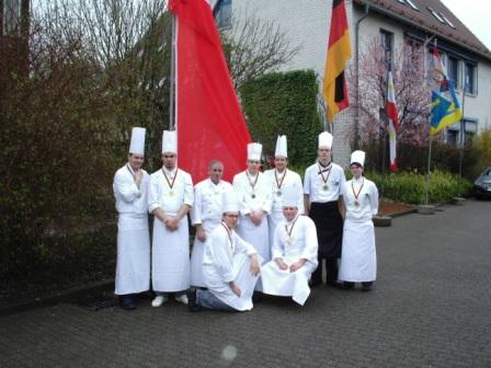 Die Teilnehmer der 4 Mannschaften des zweiten Wettkampftages mit dem Vorsitzenden des Köchevereins Fischland-Darß e.V. Hans Martens, Top-Ausbilder des Jahres 2007 (3. v. l.), vor der Fahne des Hauptsponsors des Wettbewerbs um den Küstenfischpokal, der Sparkasse Vorpommern. Foto: Eckart Kreitlow